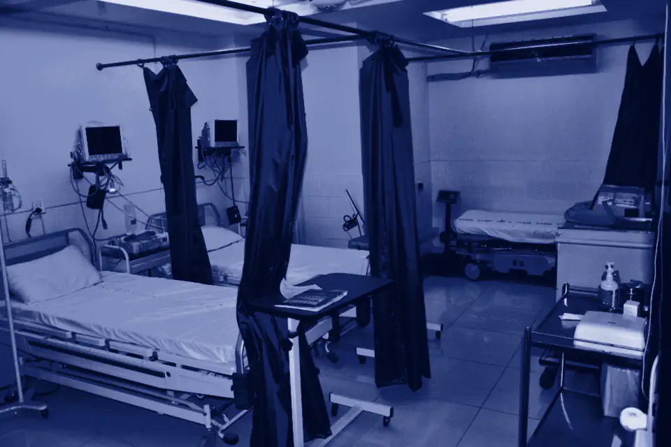 Hospital ward with beds, monitors and blue curtains in Lahore