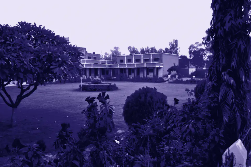 School building behind a lawn and flowering plants, Gojra, Punjab